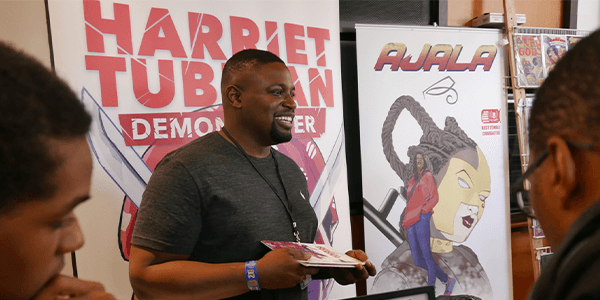 David Crownson is holding a copy of his comic book Harriet Tubman: Demon Slayer