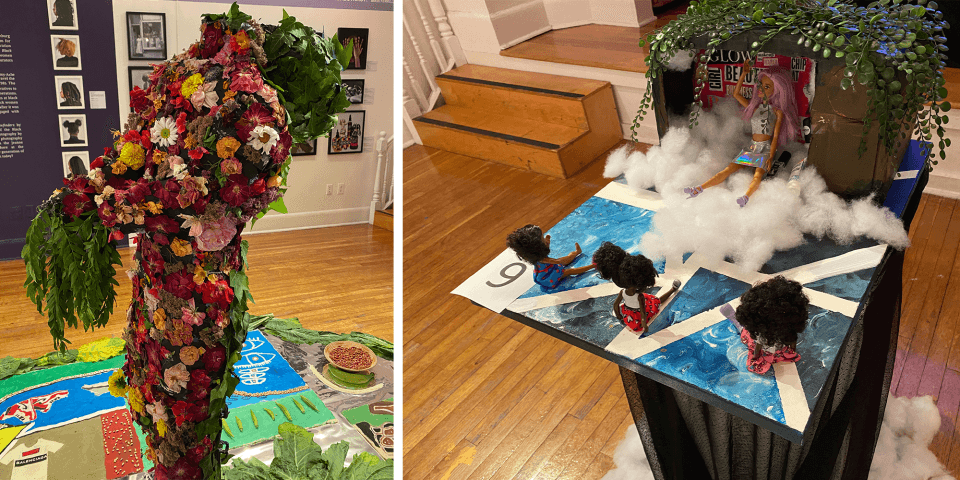 A statue of a female body made with flowers and leaves is on the left. On the right is a sculpture with three female Black children watching a program that has a white doll inside who is part of an advertisement. 