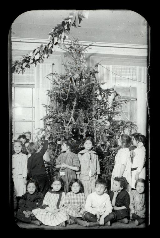 children in front of a decorated Christmas tree