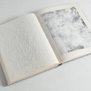 Photo of an opened book with textured pages.