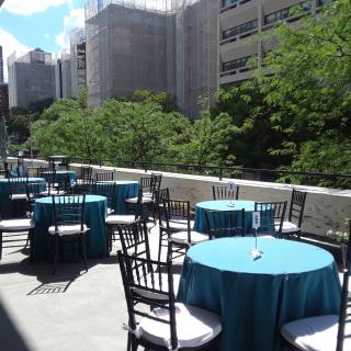 image of terrace with tables and chairs and buildings are off in a distance