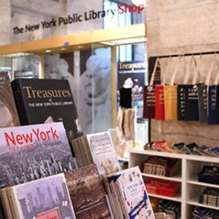 Items from The New York Public Library Shop including a book rack with titles about the Library and New York City and a range of colorful tote bags.