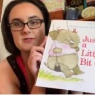 Children's Librarian holding picture book. 