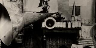 Black and white photo of man with phonograph.