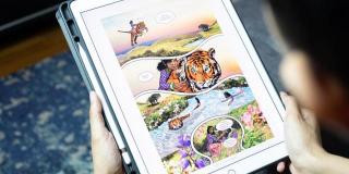 A child looks at a picture on a digital tablet