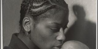 Black and white portrait of a Mother with braided hair holding a young baby
