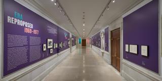 Photograph with fisheye view of exhibition showing both sides of the gallery corridor