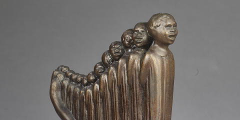 Detail of small bronze model of a larger sculpture called Lift Every Voice and Sing (Harp), which features a line of people of various heights standing close together so they resemble a harp. 