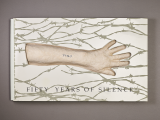 Book made of paper and plaster, with the pages of the book die-cut around the papier-mâché cast of a forearm and hand, with the fingers splayed out